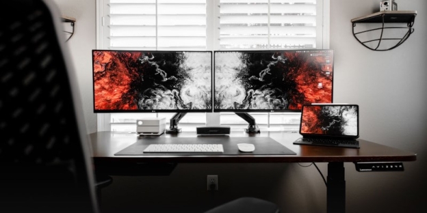 A desk with two monitors and a computer AI-generated content may be incorrect.